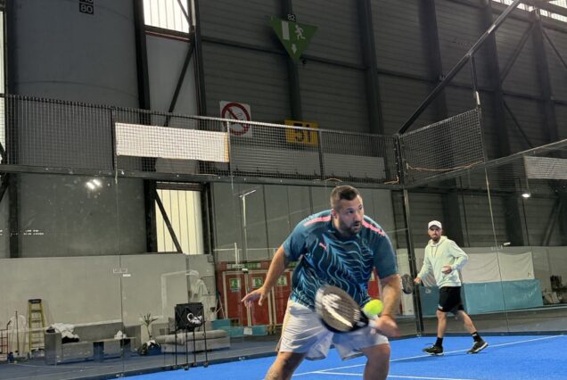 Raquette de padel en action sur court intérieur, joueurs professionnels en compétition, ambiance moderne et dynamique, équipement sportif de haute qualité, parfait pour entraînements et matchs de compétition.
