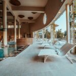 Luxueuse piscine intérieure avec chaise longues, ambiance relaxante et espace détente, idéal pour un moment de bien-être et de loisir dans un centre de sport haut de gamme.